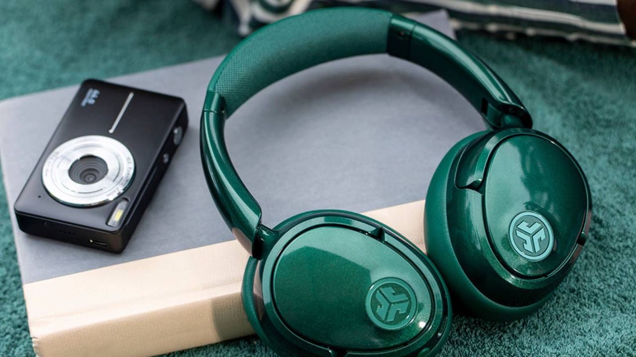 The JLab JBuds Lux in the green Jelle model on a book.
