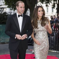 Prince William wearing tux & Kate Middleton wearing evening gown, walking on the red carpet