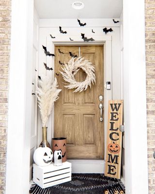 Fall porch with monochrome colors, hanging bats, pampas and welcome sign