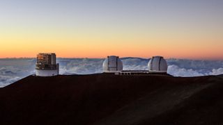 The Subaru Telescope and the twin domes of the Keck Observatory atop Maunakea in Hawaii.