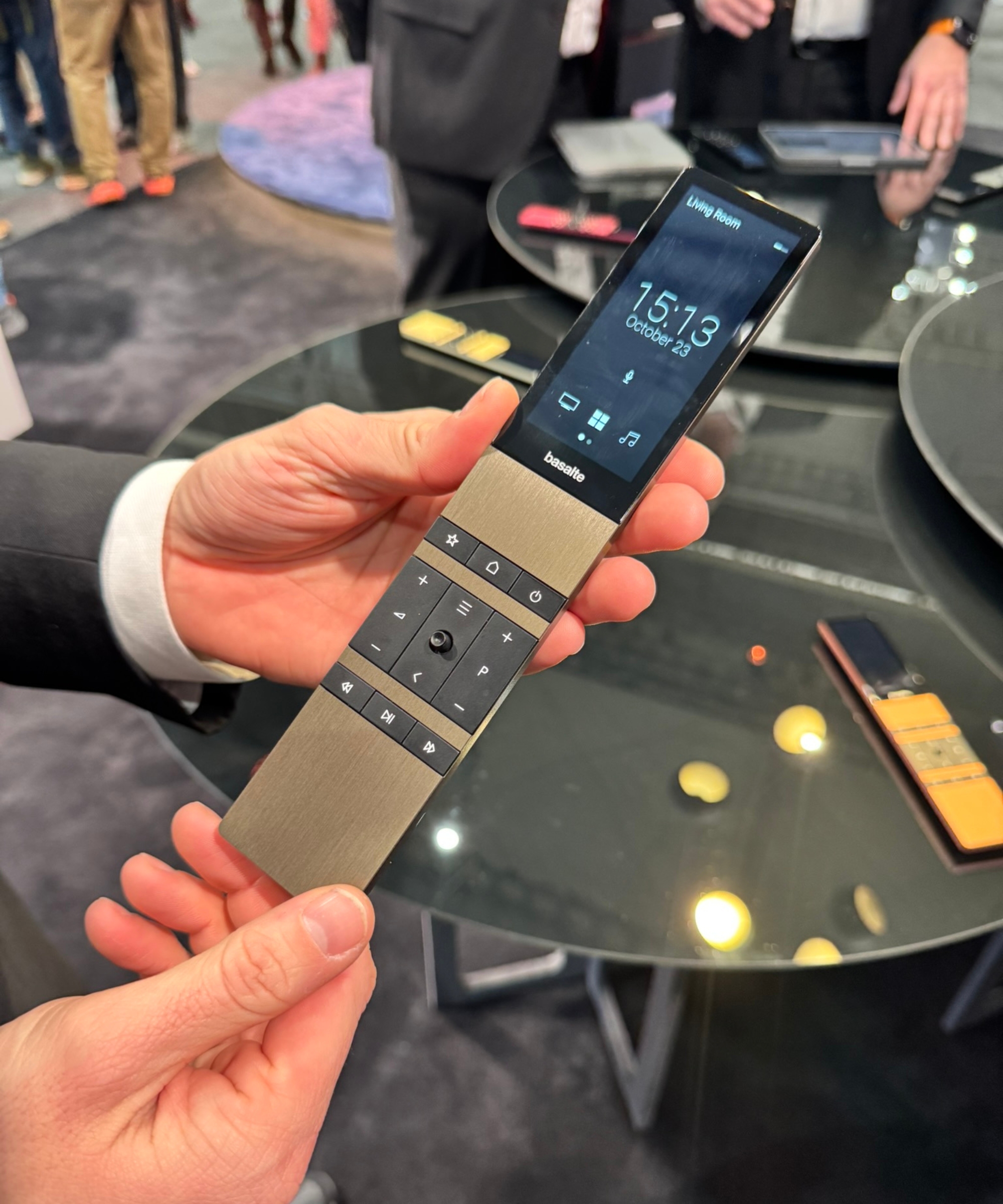 Basalte TV remote with touchscreen, held by exhibitor on display at ISE Barcelona 2026.