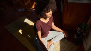 Woman meditating in a beam of sunlight