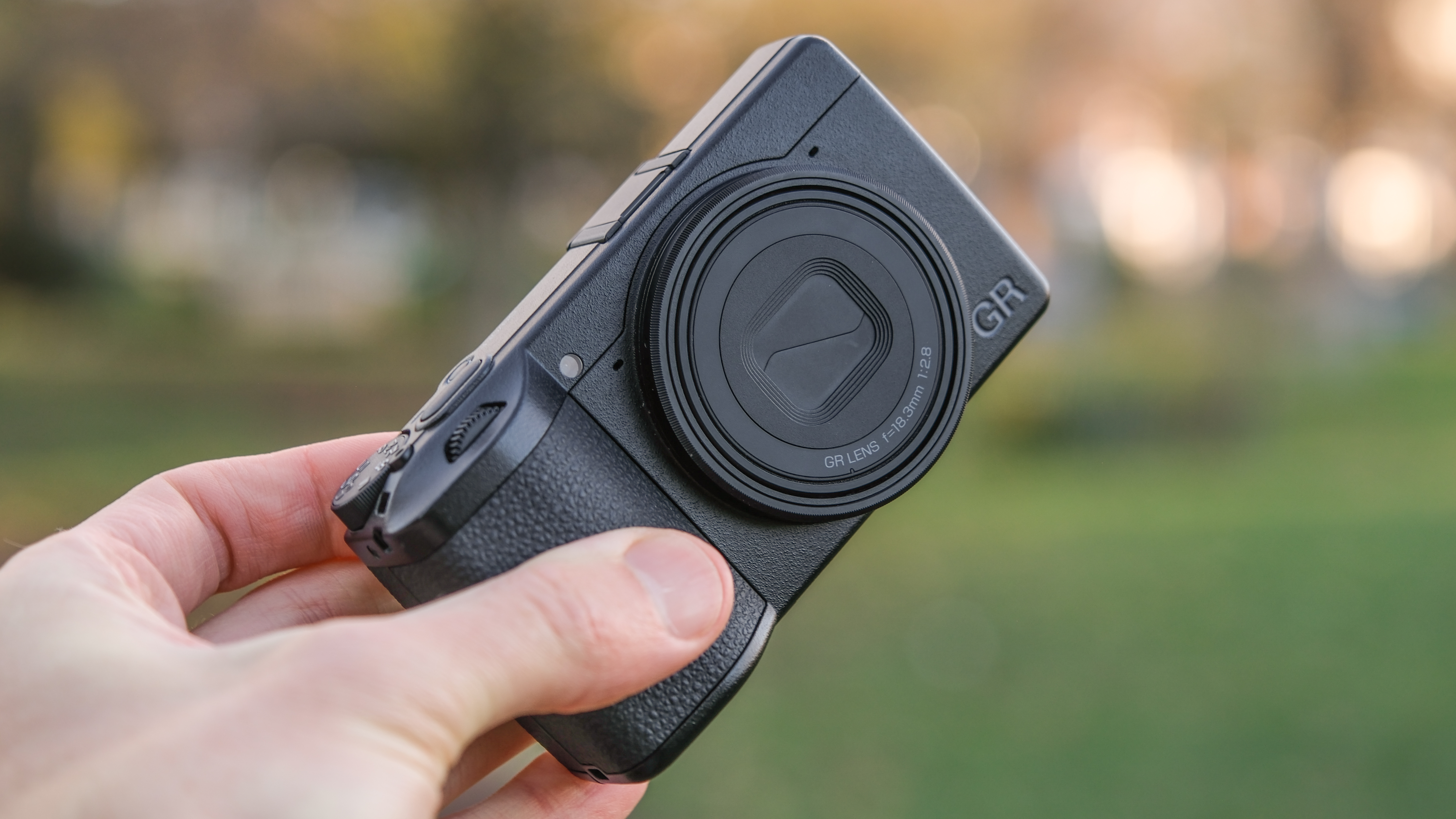 Ricoh GR IV compact camera held in a hand