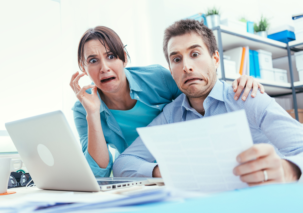 couple looks shocked at papers