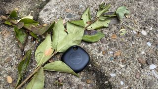 A Samsung Galaxy SmartTag Plus on the ground outside