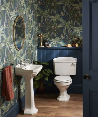 Downstairs bathroom with navy wall panels, printed wallpaper and white sanitaryware