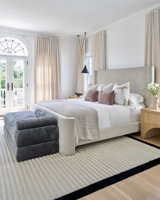 minimalist bedroom with wooden floorboards, rug, wood dressing table
