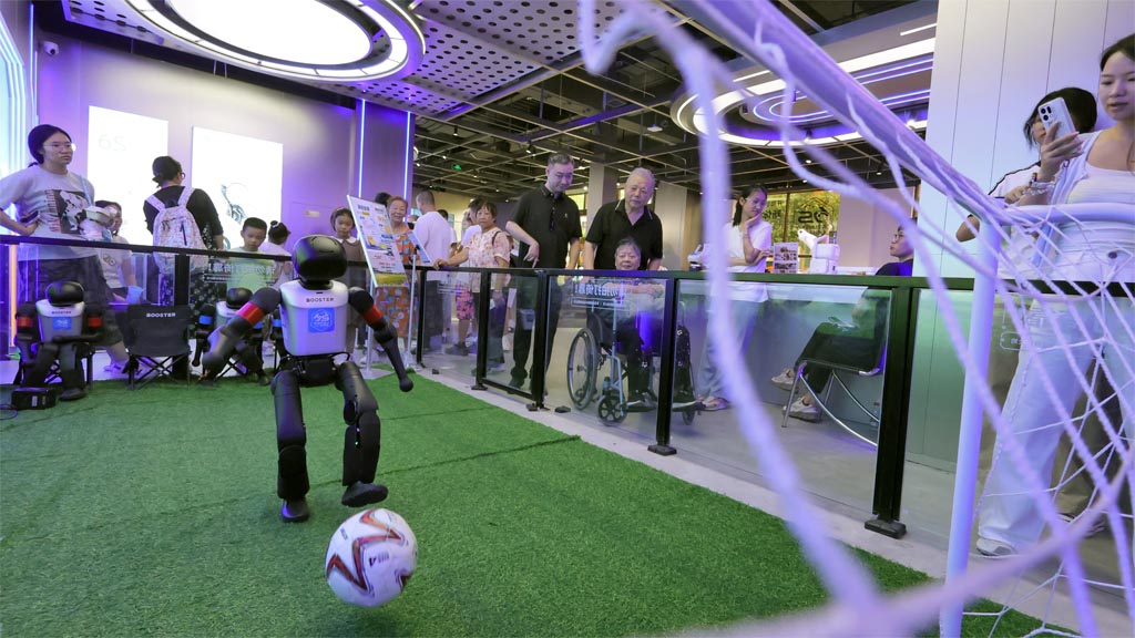 QINGDAO, CHINA - AUGUST 13: Visitors watch robots play soccer at the first robot 6S experience store in Qingdao on August 13, 2026 in Qingdao, Shandong Province of China. The store offers robots for rent and customization. (Photo by Tang Ke/VCG via Getty Images)