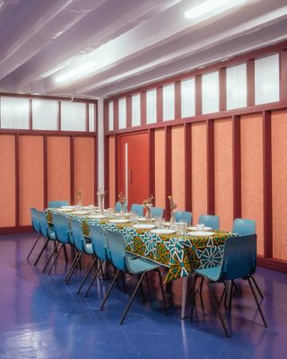 The Common Rooms with long meeting table and blue chairs