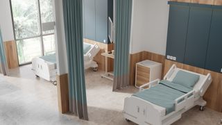 A long curtain in a hospital ward, beside a bed