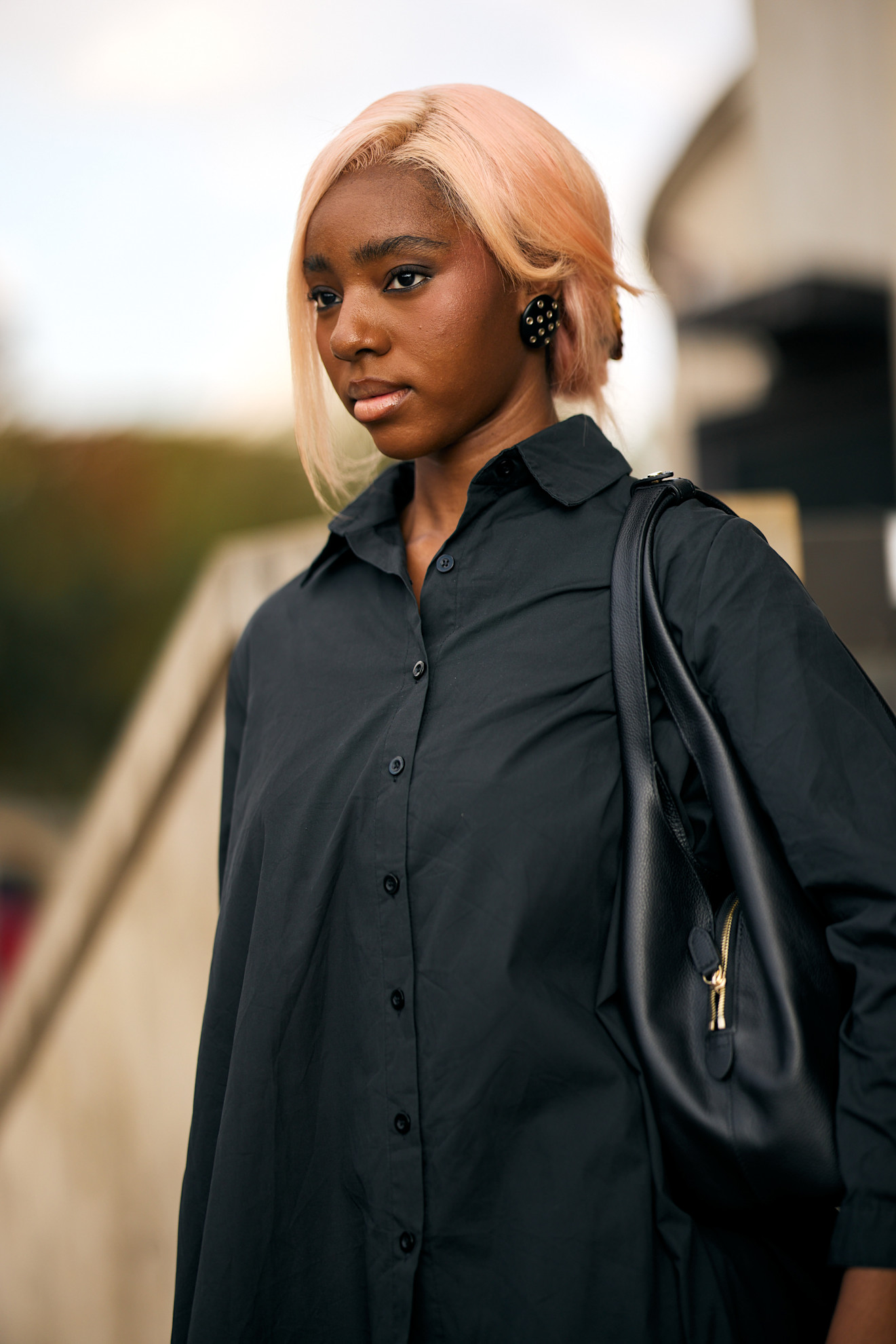 a black woman in a black shirt with pink hair