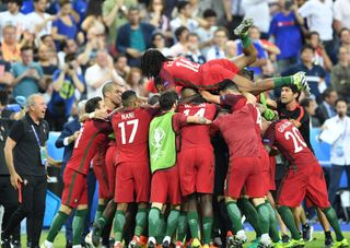 Eder celebrates with his Portugal team-mates after scoring the winner against France in the final of Euro 2016.