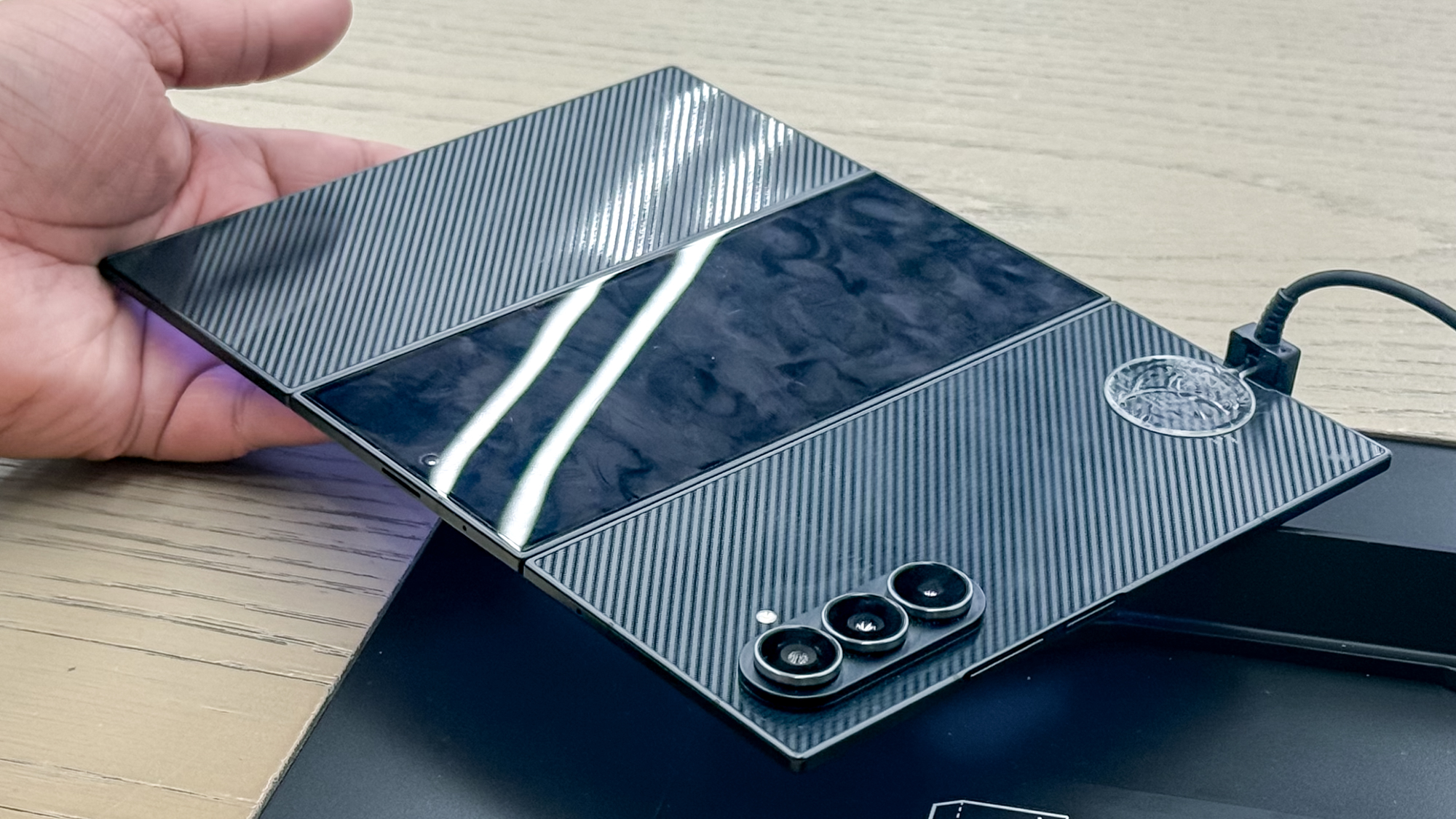 Samsung Galaxy Z TriFold unfolded, showing the back covered with fingerprints