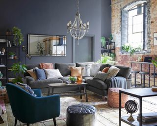 industrial boho style loft lounge living room with cushions, plants and chandelier - dunelm