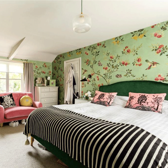 bedroom with wallpaper and pink sofa