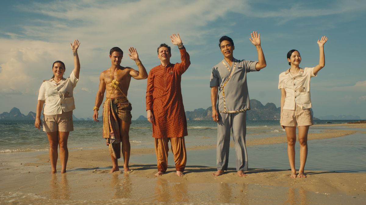 The hotel staff standing in a row waving from the shore 