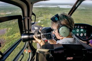 Former astronaut Roberta Bondar aboard a helicopter tracks the flight corridors used by migratory birds to gather imagery for "Space for Birds" and AMASS.