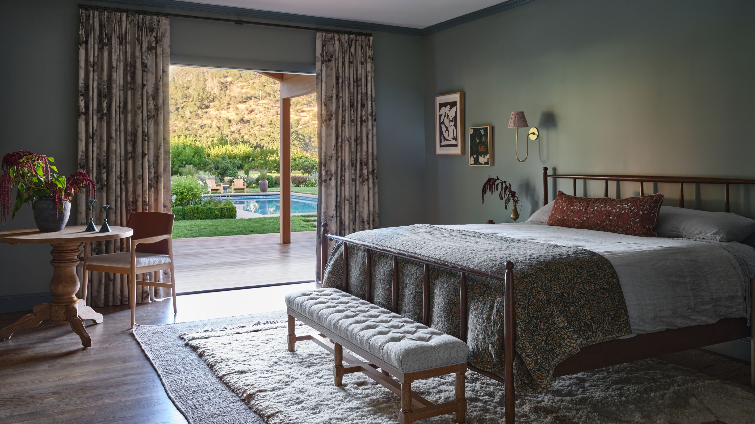 a mid blue moody primary bedroom with doors opening up to the outdoor pool deck