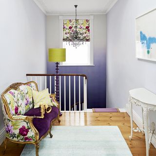 hallway with white wall and sofa with cushion and floor lamp
