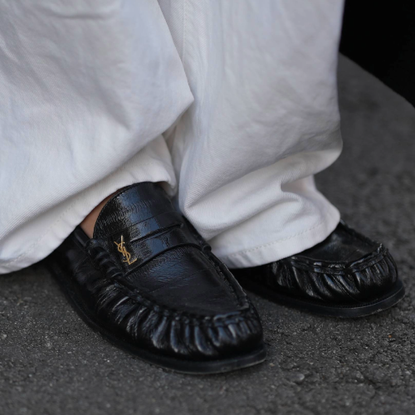 woman wearing loafers and white trousers in paris. 