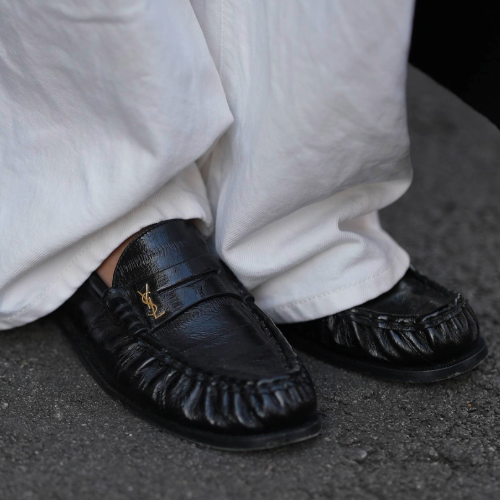 woman wearing loafers and white trousers in paris. 