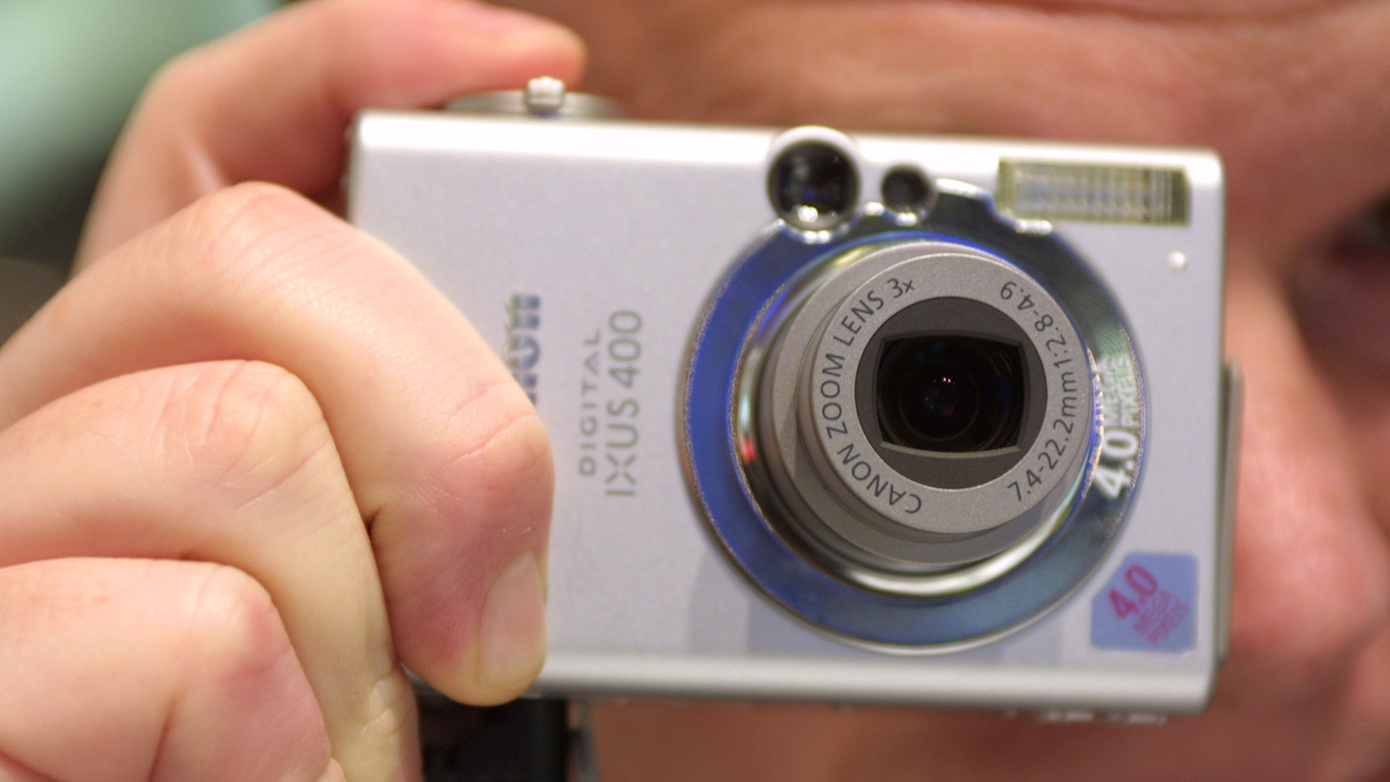 A marketing assistant demonstrates the Canon IXUS 400 digital camera at the CeBIT technology trade fair March 13, 2003 in Hanover, Germany.