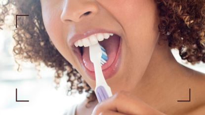 Woman using toothbrush on tongue after experiencing tongue pain
