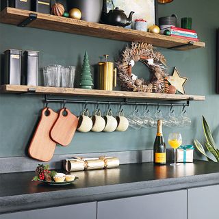 Black kitchen with wooden shelves and utensil rail