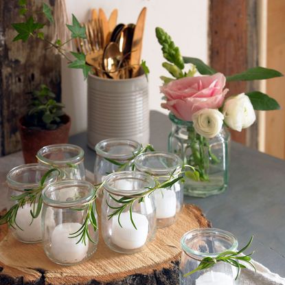 room with candle glass vase and wooden tray