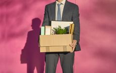 A businessman carrying a box with personal belongings.