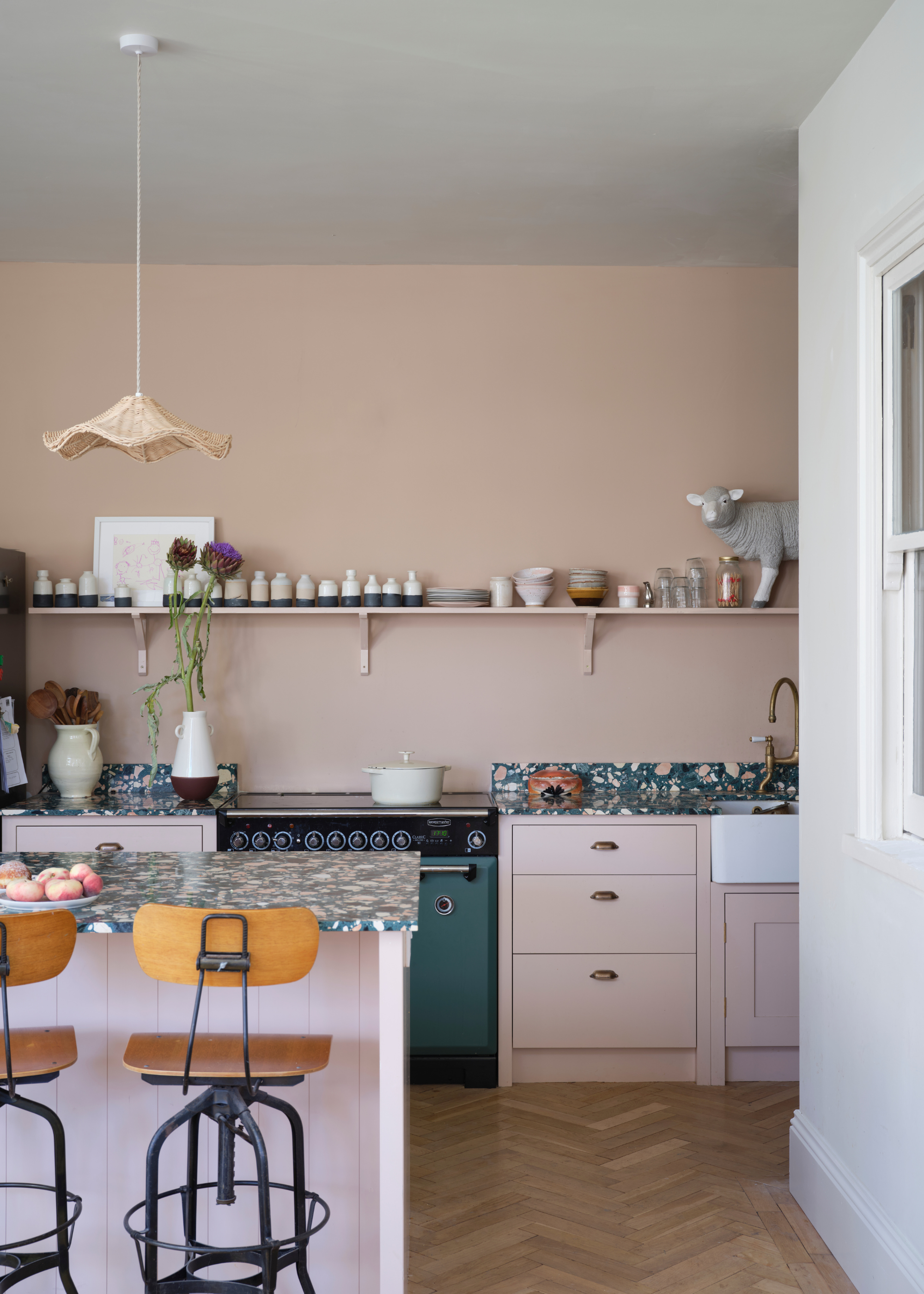 light, warm pink kitchen with a green oven