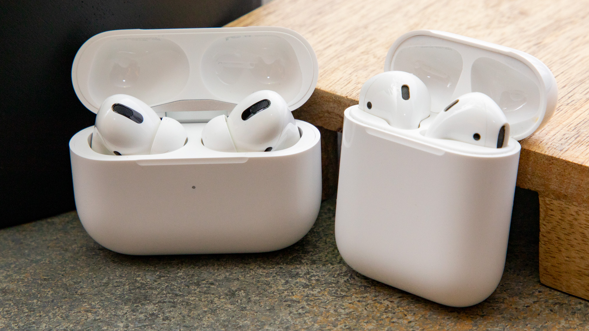 Los Apple AirPods Pro en su estuche de carga, junto a los Apple AirPods en su estuche de carga.