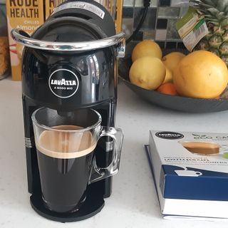 Lavazza Jolie coffee machine filling a glass with black coffee