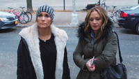 Jennifer Lopez and Leah Remini standing on the street together in Second Act