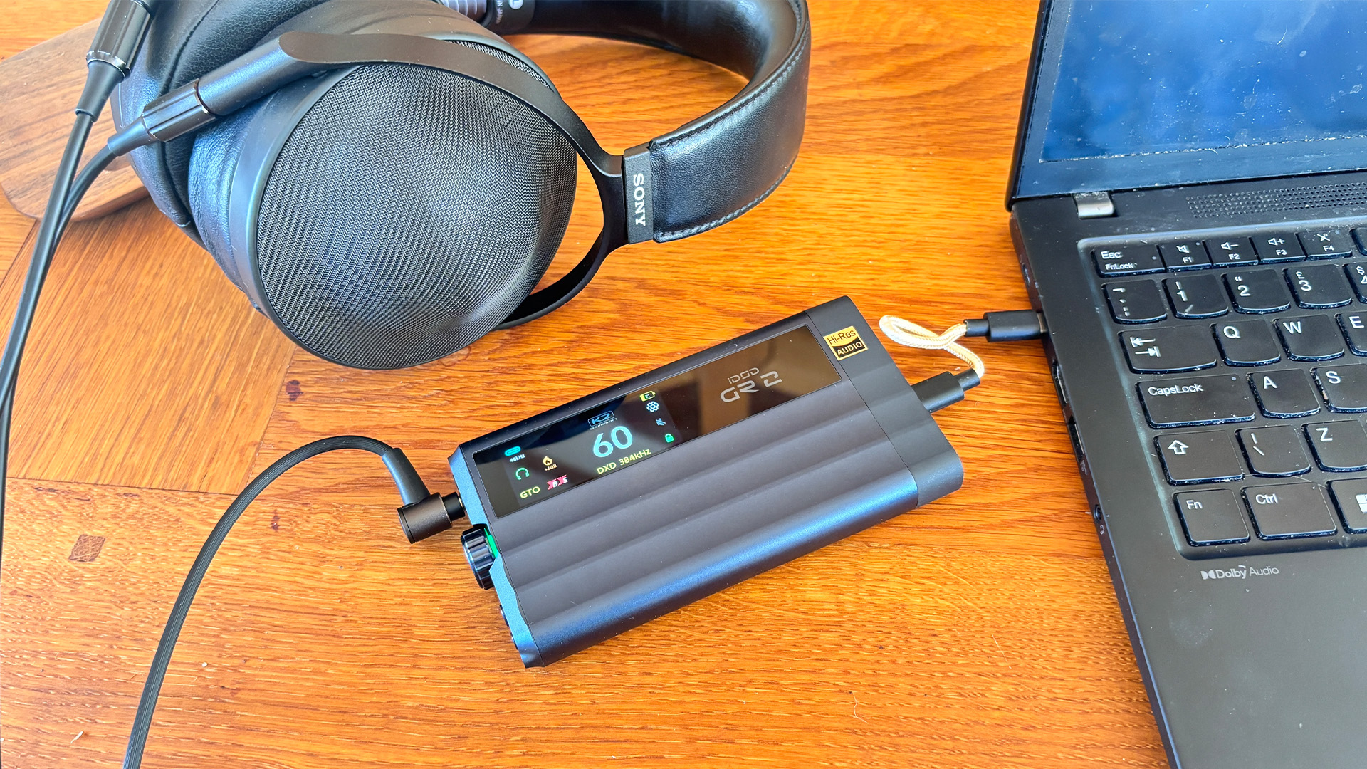 iFi iDSD GR 2 DAC on wooden desk plugged into headphones and laptop