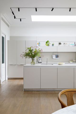 a handleless kitchen with modern ceiling track lights