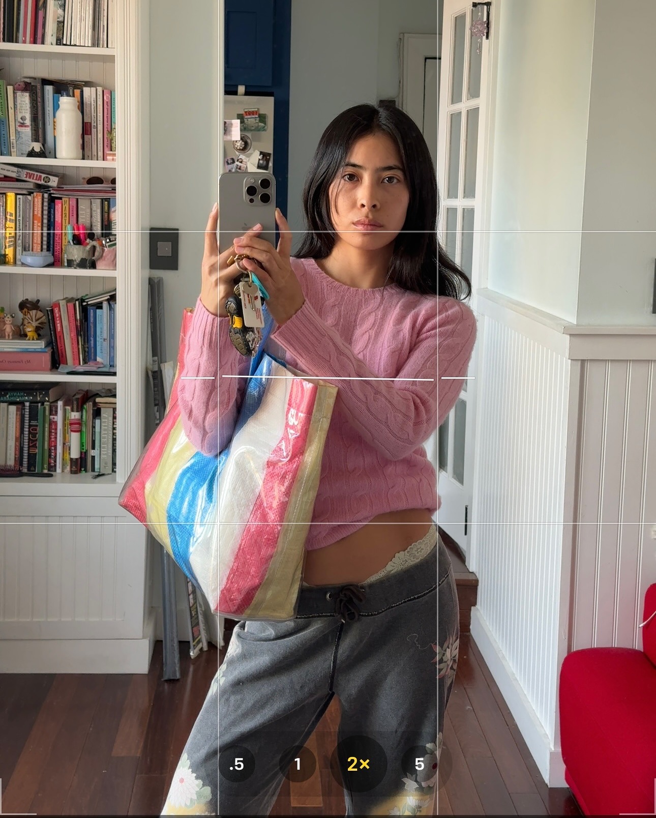 Michelle Li wearing a pink sweater and carrying a striped market tote.