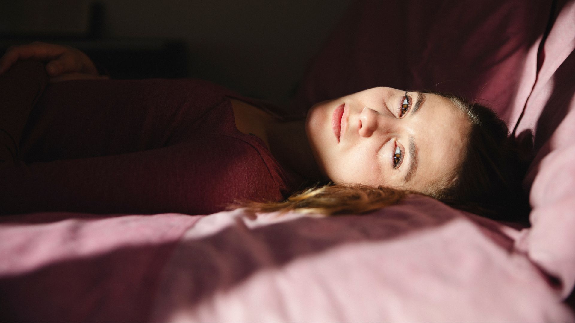 A woman struggles to sleep due to sensory issues.