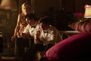 a group of young people (alison oliver as venetia catton, jacob elordi as felix catton, barry keoghan as oliver quick) wearing party clothes six on a couch, in the 2023 movie saltburn