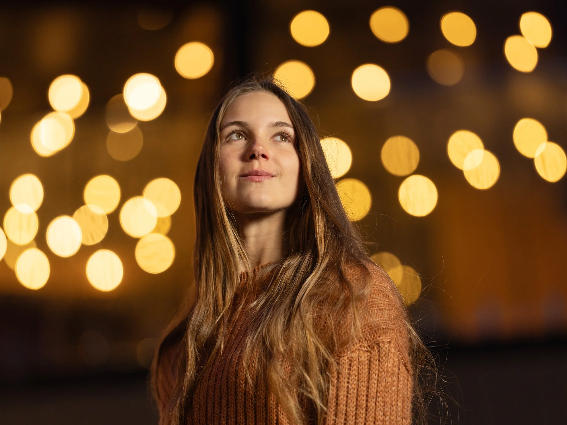 Portait of young woman with blurry night light background, taken with the Viltrox AF 135mm F1.8 lens