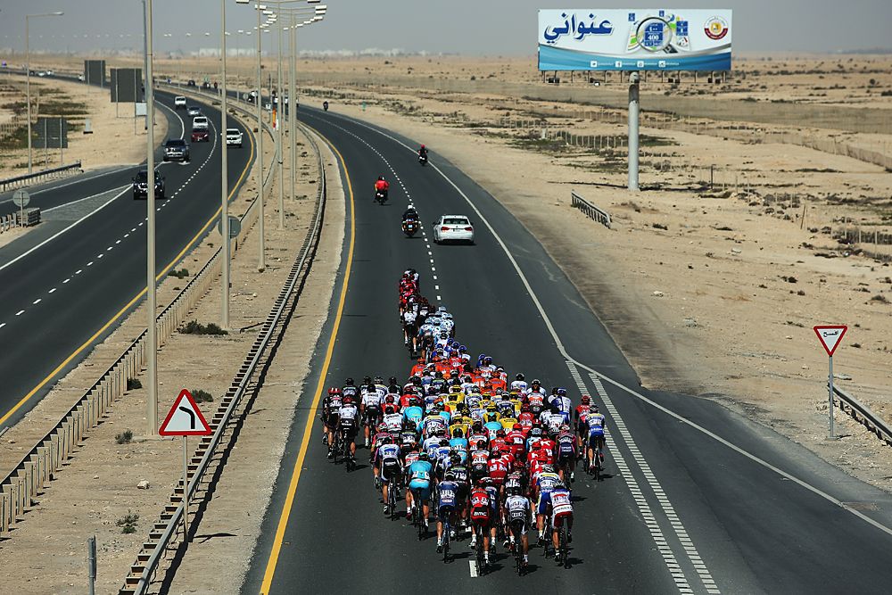Peloton racing through the desert at the Tour of Qatar