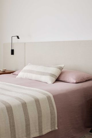 minimalist bed with stripe throw and lumbar pillow