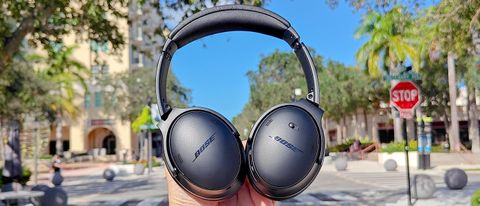 Bose QuietComfort headphones held up against a blue sky