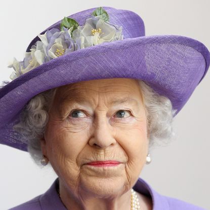 Queen Elizabeth wearing a purple hat and coat