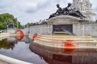 The Victoria Memorial fountain at Buckingham Palace is dyed red during the Animal Rebellion protest
