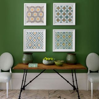 room with photoframe on green wall and wooden table