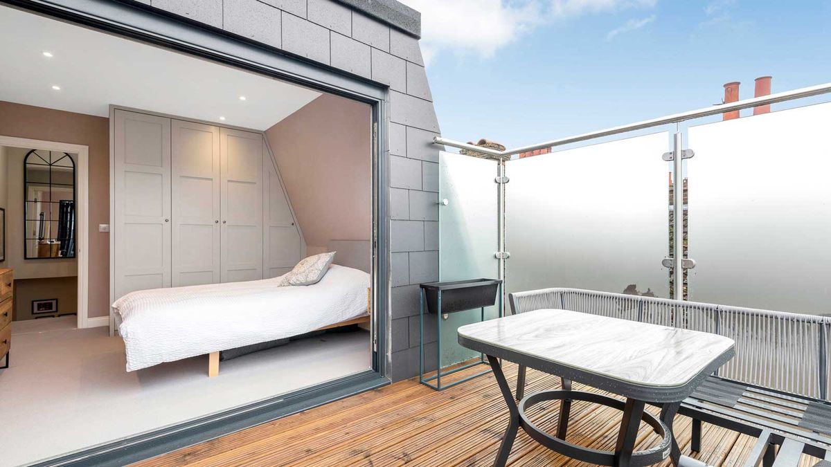 mansard loft conversion with slate cladding and balcony with frosted glass balustrades