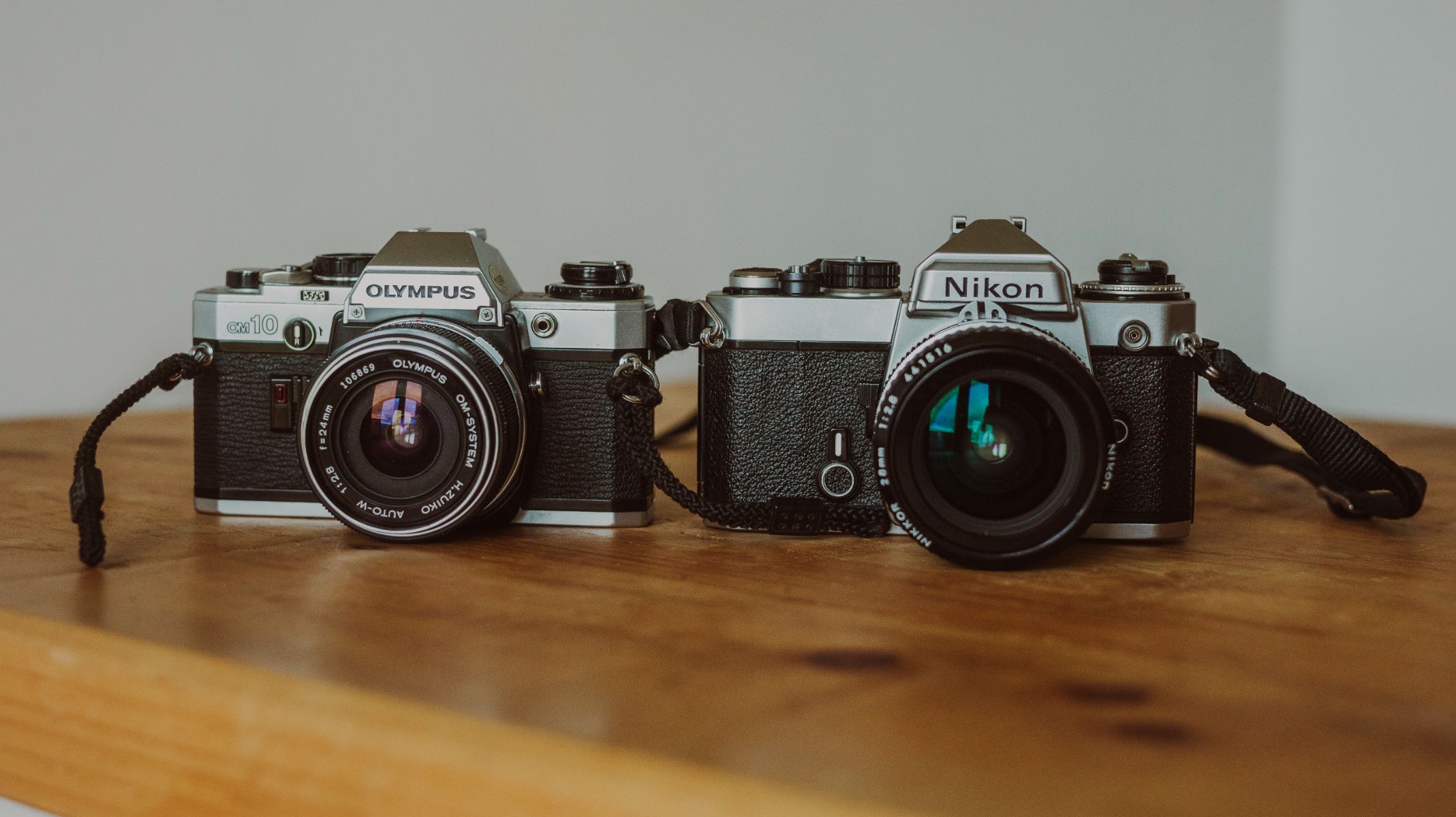 A photo of two 35mm film cameras, one is Olympus and one is Nikon