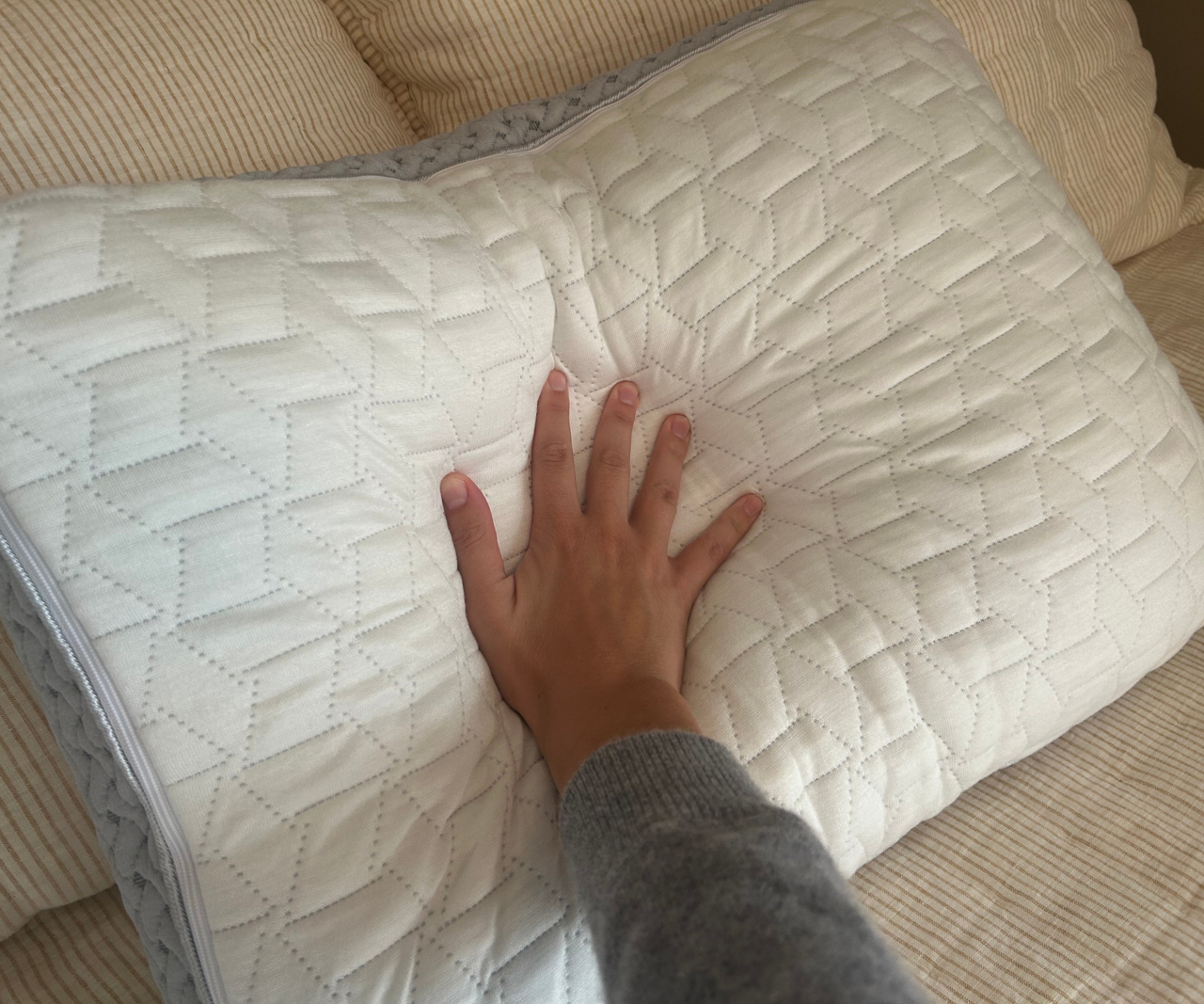 Hand pressing down on pillow
