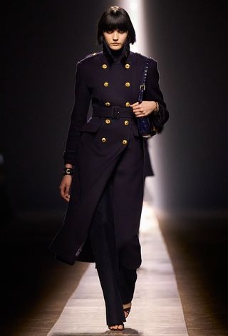 the navy color trend shown on Tom Ford's fall runway showed on a model wearing a navy army jacket with matching pants and matching sandals